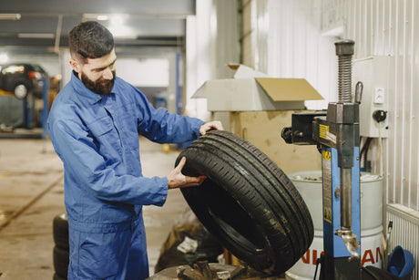 Mechanic fitting a tyre at a tyre changer