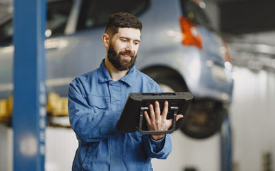 Technician using a vehicle diagnostic tablet