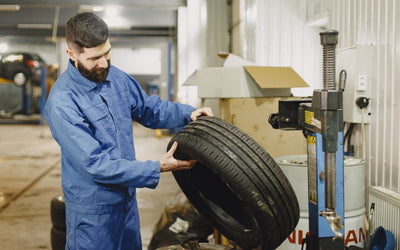 Mechanic fitting a tyre at a tyre changer